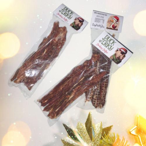 3 packages of Duck Jerky stocking stuffers on Christmas Themed Background